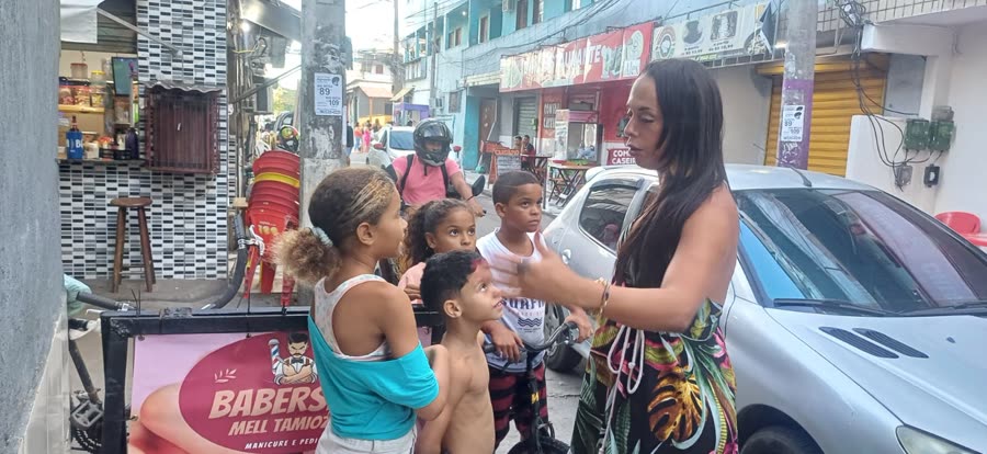 Crianças reunidas em frente à barbearia no Terreirão durante evento comunitário.